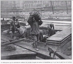 Le déchargement par la main-d'oeuvre militaire des péniches chargées de charbon et immobilisées par le gel dans le petit bras de la Seine